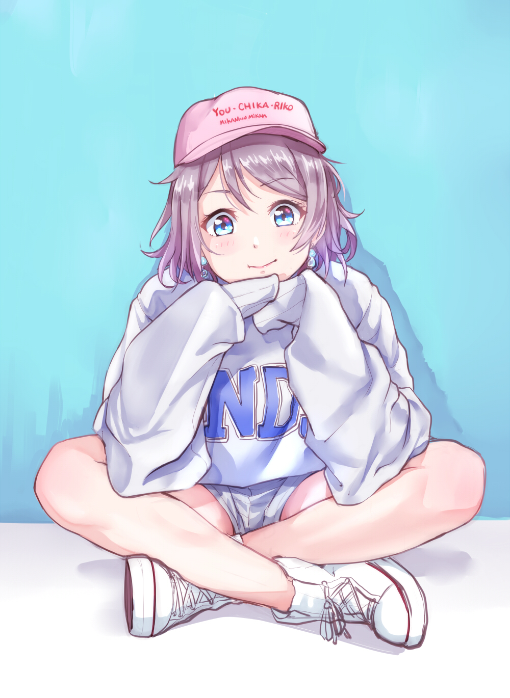 baseball_cap blue_background blue_eyes clothes_writing eyebrows_visible_through_hair grey_hair hands_together hat headwear_writing high_tops highres indian_style kanabun long_sleeves looking_at_viewer love_live! love_live!_sunshine!! pink_hat short_hair shorts sitting sleeves_past_fingers sleeves_past_wrists smile solo sweatshirt watanabe_you white_footwear