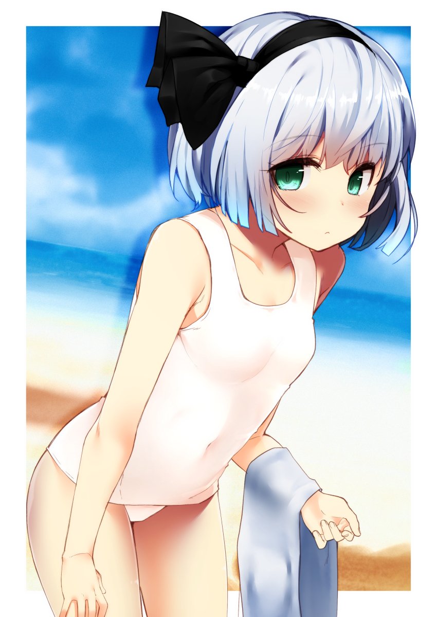 bangs bare_arms bare_shoulders beach black_hairband black_ribbon blue_sky blush border breasts collarbone commentary_request covered_navel cowboy_shot day eyebrows_visible_through_hair green_eyes hair_ribbon hairband highres holding holding_towel konpaku_youmu leaning_forward looking_at_viewer nigo_(aozoragarou) outdoors outside_border ribbon sand shadow short_hair silver_hair sky small_breasts solo standing swimsuit thighs touhou towel water white_border white_swimsuit