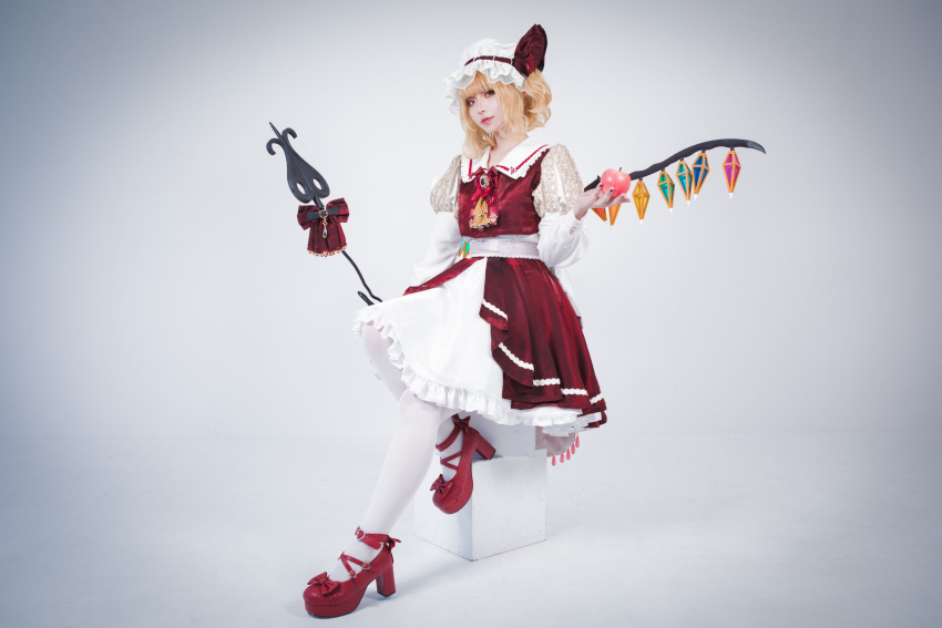 1girl adapted_costume apple ascot baked_moruru blonde_hair closed_mouth collared_shirt cosplay_photo crystal flandre_scarlet food frilled_ascot frilled_skirt frills fruit full_body hat hat_ribbon head_tilt highres holding holding_food holding_fruit holding_polearm holding_weapon juliet_sleeves laevatein_(touhou) layered_skirt long_sleeves looking_at_viewer mary_janes medium_hair mob_cap multicolored_wings one_side_up pantyhose photo_(medium) polearm puffy_sleeves red_apple red_brooch red_footwear red_ribbon red_skirt red_vest ribbon ribbon-trimmed_headwear ribbon_trim shirt shoes simple_background skirt solo touhou vest weapon white_background white_headwear white_pantyhose white_shirt white_skirt wings yellow_ascot