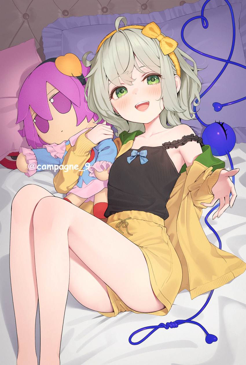 1girl bare_legs bed_sheet black_camisole blush bow_hairband camisole character_doll feet_out_of_frame fumo_(doll) green_hair hairband heart heart_of_string highres kanpa_(campagne_9) knees_up komeiji_koishi komeiji_satori looking_at_viewer lying on_back pillow shirt short_hair short_shorts shorts smile solo third_eye touhou twitter_username yellow_hairband yellow_shirt yellow_shorts