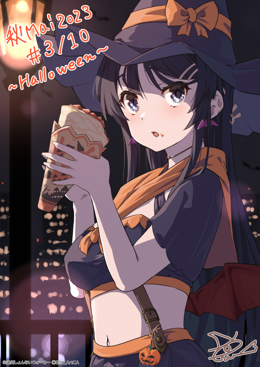 1girl bat_wings black_hair black_headwear black_shirt black_skirt blue_eyes cape crepe food food_on_face hair_ornament hairclip halloween hat highres holding holding_food long_hair looking_at_viewer navel open_mouth orange_cape pumpkin rabbit_hair_ornament raiz_art_works sakurajima_mai seishun_buta_yarou shirt signature skirt solo wings witch_hat