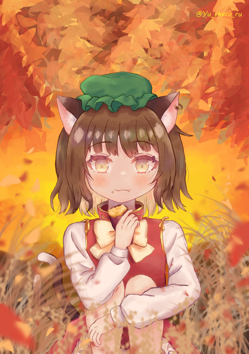 1girl :3 absurdres animal_ear_piercing animal_ears artist_name blurry blurry_foreground brown_eyes brown_hair cat_ears cat_tail chen closed_mouth commentary_request depth_of_field earrings fang fang_out food food_on_face frills gold_trim green_headwear hand_up hat highres holding holding_food jewelry knees_to_chest leaf leaf_background light_smile long_sleeves looking_at_viewer mob_cap multiple_tails nekomata petite petticoat puffy_long_sleeves puffy_sleeves red_skirt red_vest short_hair single_earring sitting skin_fang skirt skirt_set solo sweet_potato tail touhou twitter_username two_tails vest yu_chaco_ru