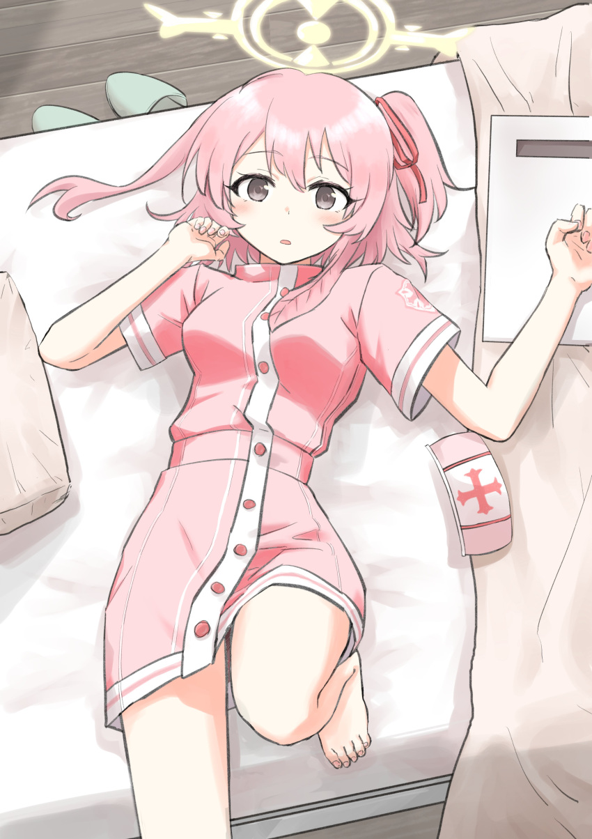 1girl absurdres barefoot bed blanket blue_archive blush dress feather_hair halo hat highres imonoiruku leg_up lying nurse nurse_cap on_back on_bed one_side_up pillow pink_dress pink_hair serina_(blue_archive) short_hair solo thighs