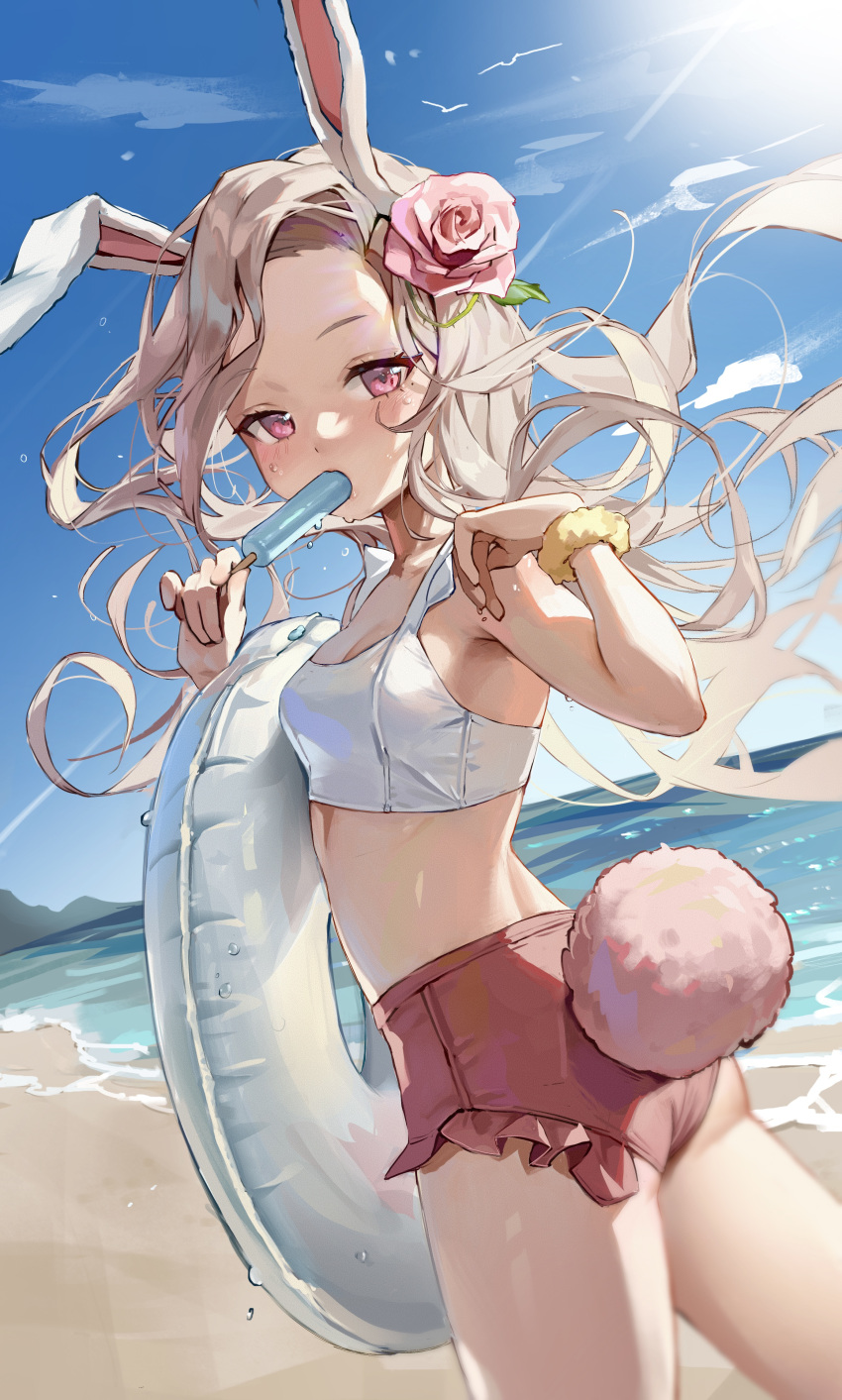 1girl absurdres animal_ears beach blue_sky blush bodiedwile breasts cleavage commentary day eating flower food hair_flower hair_ornament hand_up highres holding holding_food holding_innertube holding_popsicle horizon innertube light_brown_hair long_hair looking_at_viewer looking_back mole mole_under_eye ocean original outdoors pink_eyes pink_flower pink_rose popsicle rabbit_ears rabbit_girl rabbit_tail rose sky small_breasts sun swimsuit tail