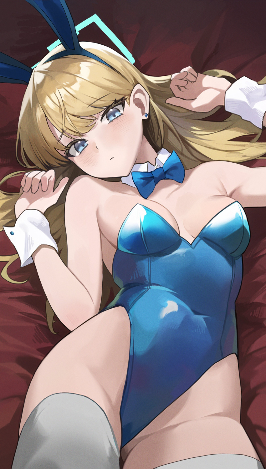 1girl absurdres animal_ears blonde_hair blue_archive blue_bow blue_bowtie blue_eyes blue_halo blue_leotard blush bow bowtie breasts closed_mouth commentary covered_navel detached_collar earrings expressionless fake_animal_ears halo highleg highleg_leotard highres jewelry leotard long_hair looking_at_viewer lying medium_breasts official_alternate_costume on_back ori_(0rizuru) playboy_bunny rabbit_ears solo thighhighs toki_(blue_archive) toki_(bunny)_(blue_archive) white_thighhighs wrist_cuffs
