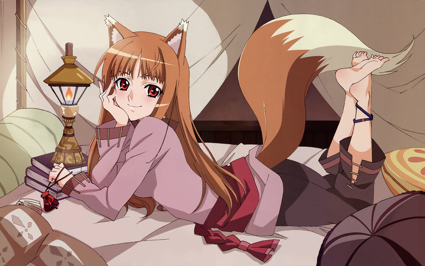 animal_ears anklet barefoot bed blush book brown_hair chin_rest feet highres holo jewelry lantern long_hair lying official_art on_stomach pillow pouch red_eyes sadakata_kikuko sash smile soles solo spice_and_wolf tail wallpaper wolf_ears wolf_tail