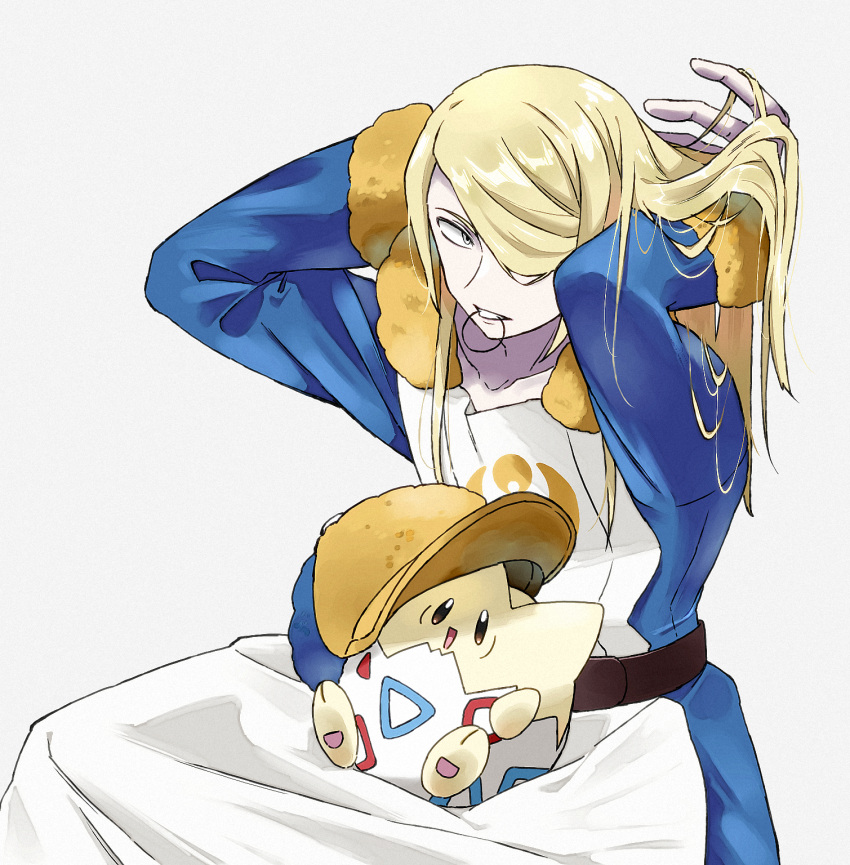 1boy ayuma_night bishounen blonde_hair blue_jumpsuit fur-trimmed_jumpsuit fur_trim ginkgo_guild_uniform grey_eyes hair_over_one_eye hair_tie hands_in_own_hair highres jumpsuit long_hair looking_at_viewer male_focus multicolored_clothes multicolored_headwear pokemon pokemon_(creature) pokemon_legends:_arceus simple_background sitting solo teeth togepi two-tone_headwear tying_hair volo_(pokemon) white_background