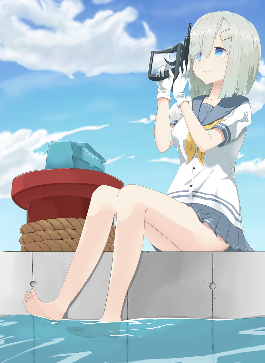 bare_legs barefoot blue_eyes blue_sky bollard brown_hair cloud day gloves grey_skirt hair_ornament hair_over_one_eye hairclip hamakaze_(kantai_collection) harbor highres hoosu_(f-o-c) kantai_collection looking_up neckerchief no_legwear pleated_skirt sailor_collar school_uniform serafuku short_hair short_sleeves silver_hair sitting skirt sky smile soaking_feet solo water white_gloves