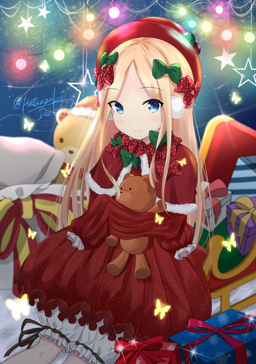 abigail_williams_(fate/grand_order) bangs blonde_hair bloomers blue_eyes blurry blurry_background blush bow box bug butterfly capelet christmas_ornaments closed_mouth commentary depth_of_field dress eyebrows_visible_through_hair fate/grand_order fate_(series) forehead fur-trimmed_capelet fur_trim gift gift_box green_bow hair_bow hat hatsuzuki_527 highres insect long_hair long_sleeves looking_at_viewer object_hug parted_bangs polka_dot polka_dot_bow red_bow red_capelet red_dress red_hat sack signature sitting sled sleeves_past_wrists smile solo sparkle star stuffed_animal stuffed_toy teddy_bear underwear very_long_hair white_bloomers