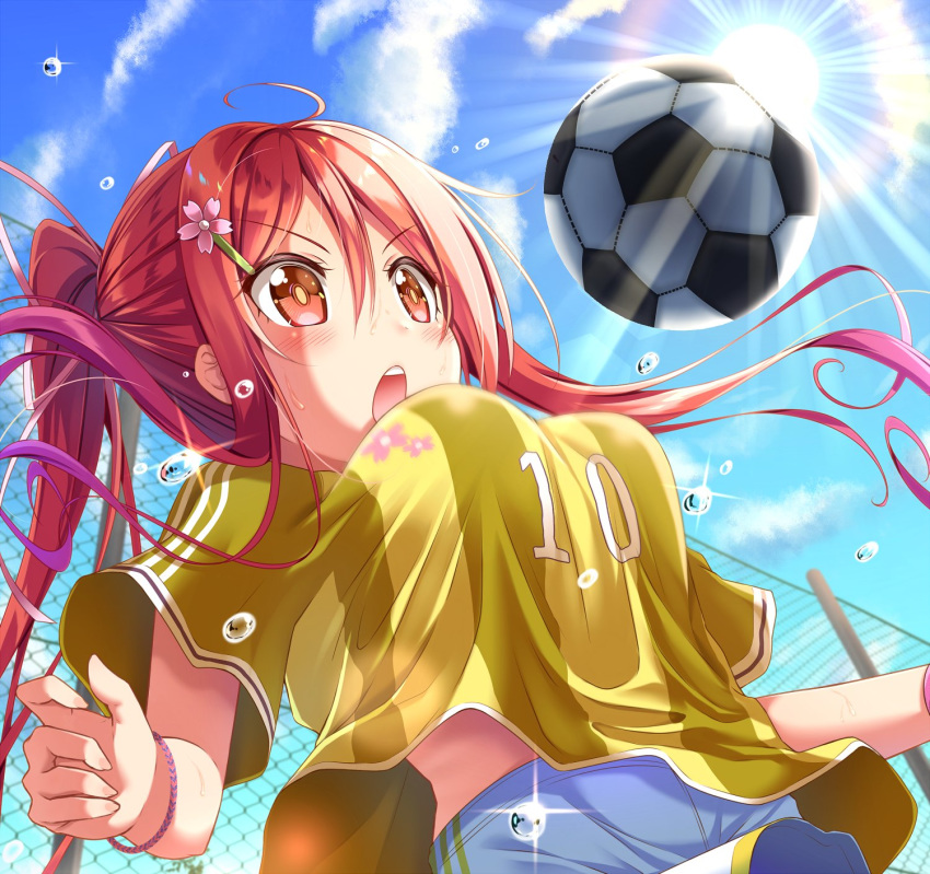 :o ball blue_sky blush breasts chain-link_fence clothes_writing cloud commentary_request day fence flower gurande_(g-size) hair_flower hair_ornament hairclip highres light_rays long_hair medium_breasts moe2017 open_mouth original outdoors ponytail red_eyes red_hair short_sleeves shorts sidelocks sky soccer soccer_ball soccer_field soccer_uniform sparkle sportswear sun sunbeam sunlight sweat sweatband v-shaped_eyebrows white_shorts