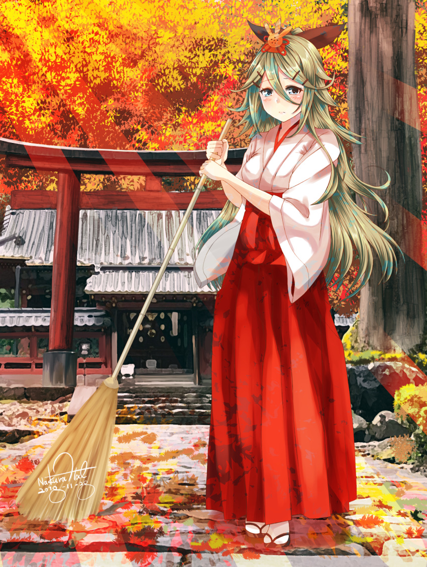 autumn_leaves bangs blue_eyes blush breasts broom commentary_request full_body green_hair hair_between_eyes hair_ornament hair_ribbon hairclip hakama highres holding holding_broom japanese_clothes kantai_collection leaf long_hair long_sleeves looking_at_viewer maple_leaf miko nakura_haru outdoors ponytail red_hakama ribbon sandals shrine sidelocks signature socks solo sunset sweeping white_footwear wide_sleeves yamakaze_(kantai_collection)
