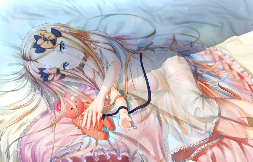 1girl abigail_williams_(fate/grand_order) bangs bare_shoulders black_bow blonde_hair blue_eyes blush bow breasts covered_navel dress fate/grand_order fate_(series) forehead gown hair_bow highres holding holding_stuffed_animal long_hair looking_at_viewer lying on_side open_mouth orange_bow parted_bangs sakazakinchan small_breasts stuffed_animal stuffed_toy teddy_bear thighs