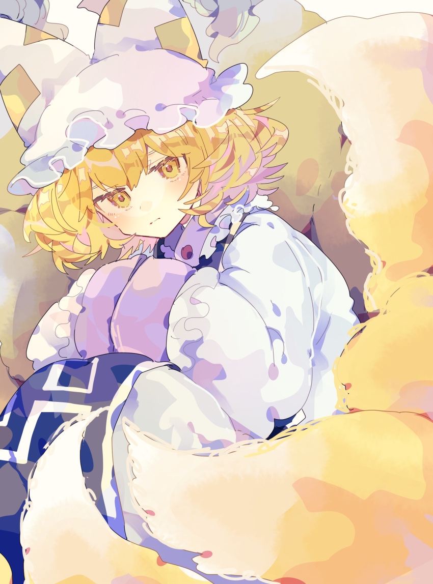 1girl absurdres animal_hat blonde_hair blue_tabard closed_mouth commentary dress expressionless feet_out_of_frame fox_tail hands_in_opposite_sleeves hat highres knees_up looking_at_viewer medium_hair mob_cap multiple_tails nikorashi-ka solo tabard tail touhou white_dress white_headwear yakumo_ran yellow_eyes