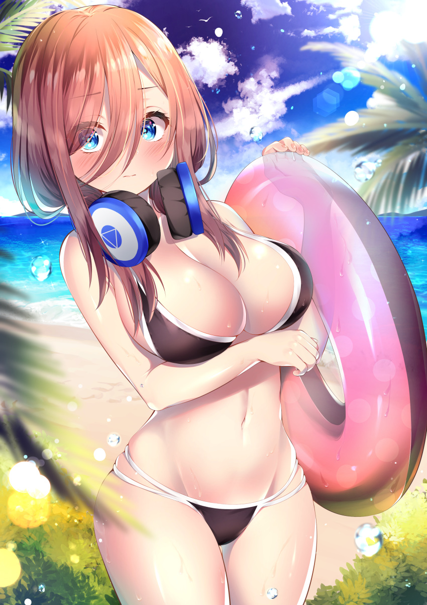 1girl absurdres arm_under_breasts bare_arms bare_shoulders bikini black_bikini blue_eyes blue_sky breasts brown_hair bubble cleavage closed_mouth cloud commentary_request cowboy_shot day go-toubun_no_hanayome groin hair_between_eyes hair_over_shoulder headphones headphones_around_neck highres innertube large_breasts lens_flare long_hair looking_at_viewer nakano_miku nari_(narikashi) navel ocean outdoors palm_leaf sky solo stomach sun sunlight swimsuit thighs water wet