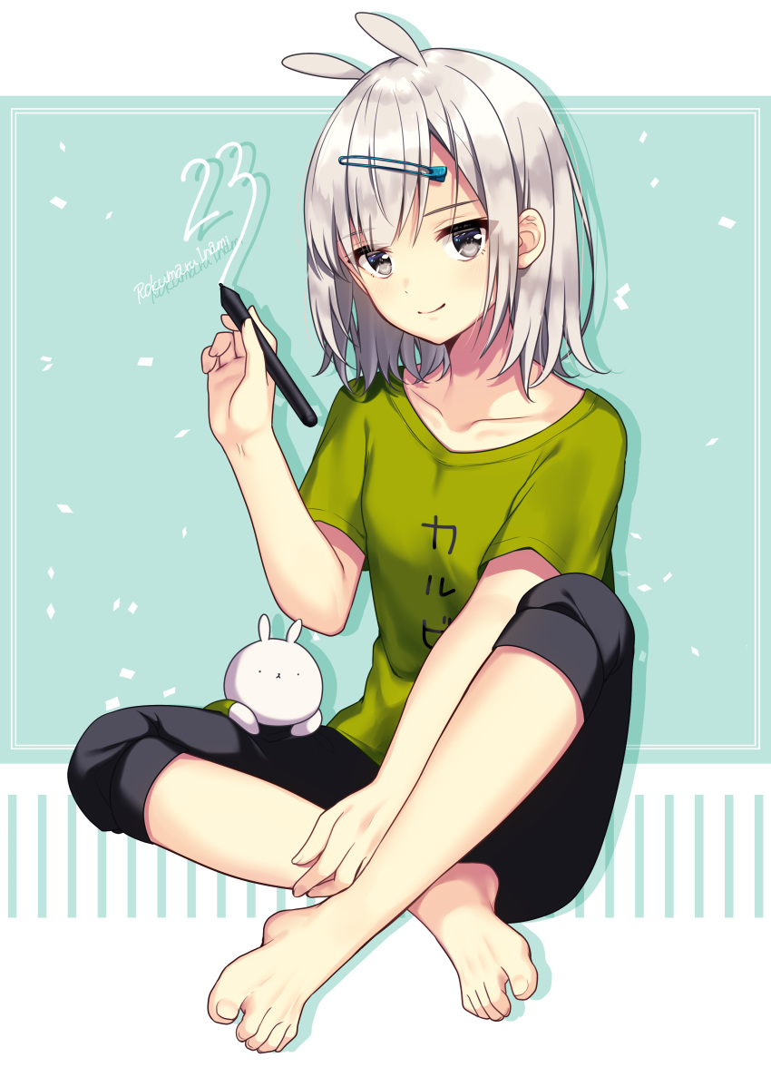 1girl absurdres animal_ears bangs barefoot black_shorts blush bunny_ears closed_mouth clothes_writing collarbone commentary_request eyebrows_visible_through_hair feet full_body green_shirt grey_eyes hair_between_eyes hair_ornament hairclip highres holding holding_stylus ichiren_namiro original shirt short_sleeves shorts signature silver_hair sitting smile solo stylus toenails translation_request
