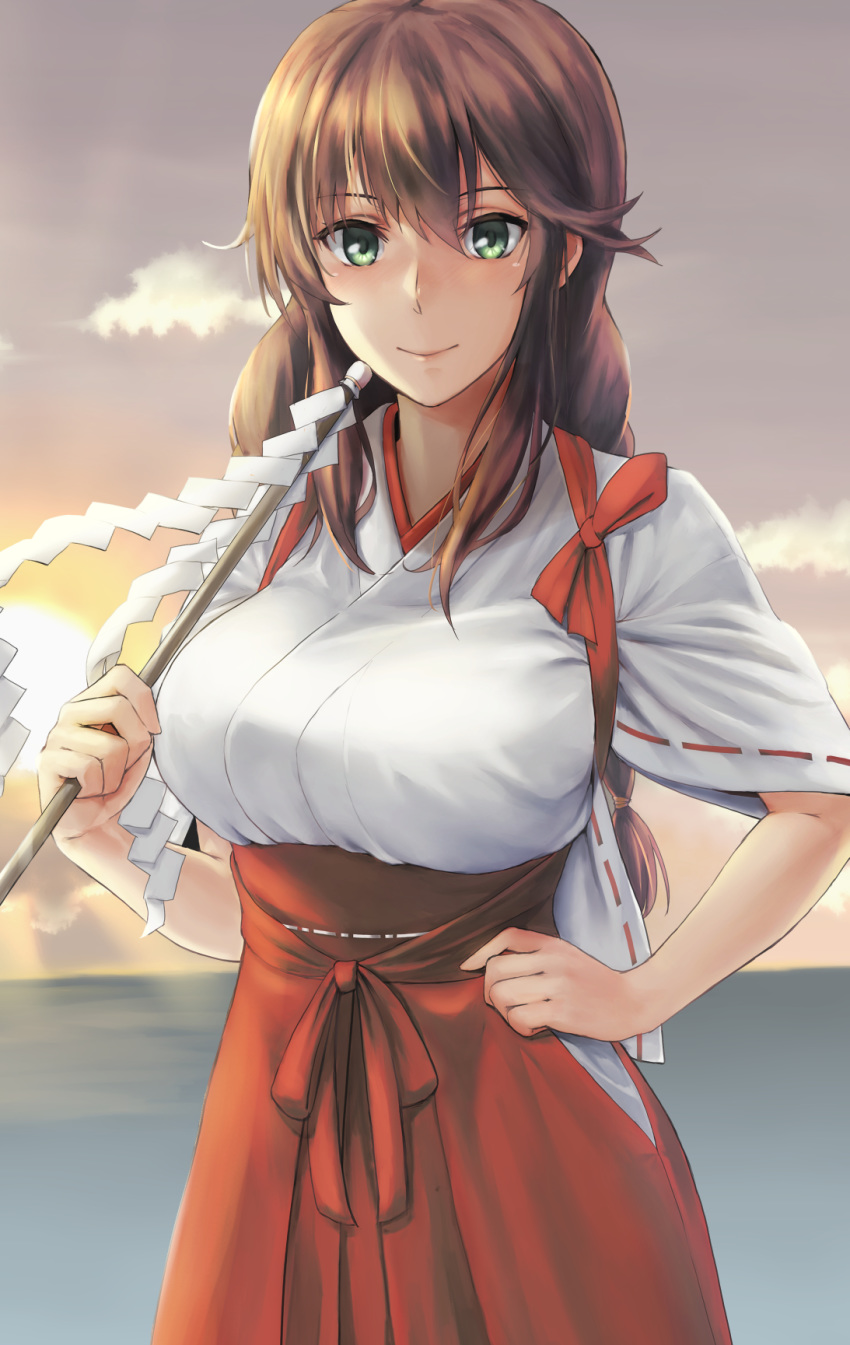 1girl alternate_costume braid breasts brown_hair commentary_request gohei green_eyes hair_between_eyes hakama highres holding japanese_clothes kantai_collection kokuzoo large_breasts long_hair miko noshiro_(kantai_collection) red_hakama ribbon-trimmed_sleeves ribbon_trim shide short_sleeves single_braid smile solo sun upper_body