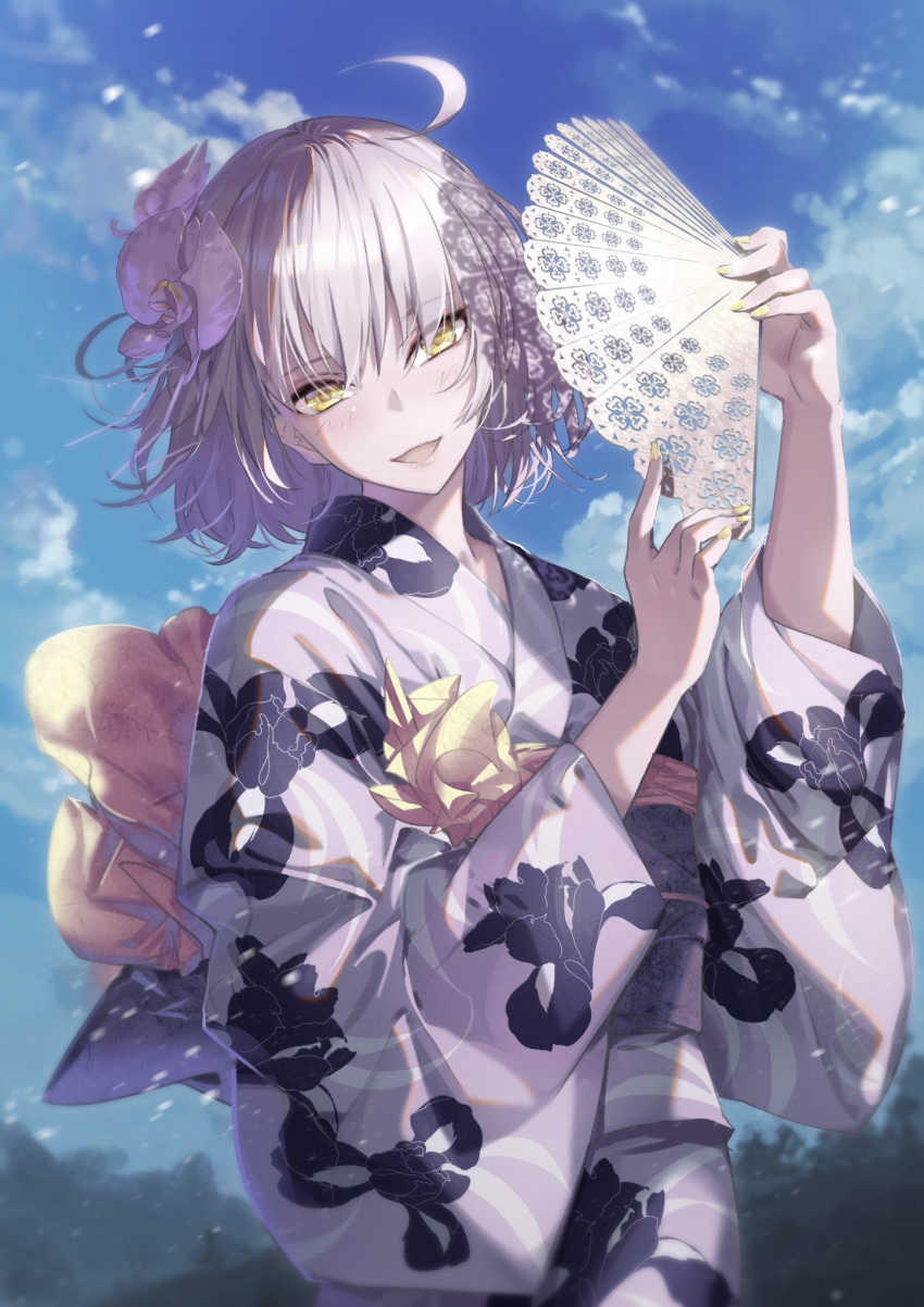 1girl ahoge alternate_costume bangs breasts cloud eyebrows_visible_through_hair fan fate/grand_order fate_(series) floral_print flower folding_fan hair_between_eyes hair_flower hair_ornament highres holding holding_fan japanese_clothes jeanne_d'arc_(alter)_(fate) jeanne_d'arc_(fate)_(all) kimono long_sleeves looking_at_viewer obi open_mouth outdoors paper_fan parted_lips print_kimono sash short_hair silver_hair sky smile solo tsurukame white_kimono wide_sleeves yellow_eyes yellow_nails