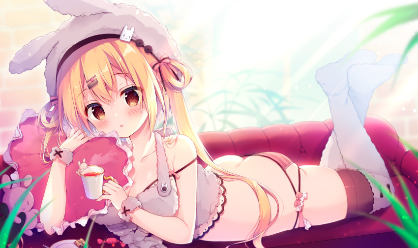 1girl animal_hat ass bangs bare_arms bare_shoulders blonde_hair brown_eyes bunny_hat candy cup feet food hair_ornament hairclip hat heart heart_pillow highres holding holding_cup indoors izumiyuhina long_hair looking_at_viewer lying on_stomach original panties pillow solo strap_slip striped striped_panties the_pose thighhighs two_side_up underwear white_headwear white_legwear wrist_cuffs