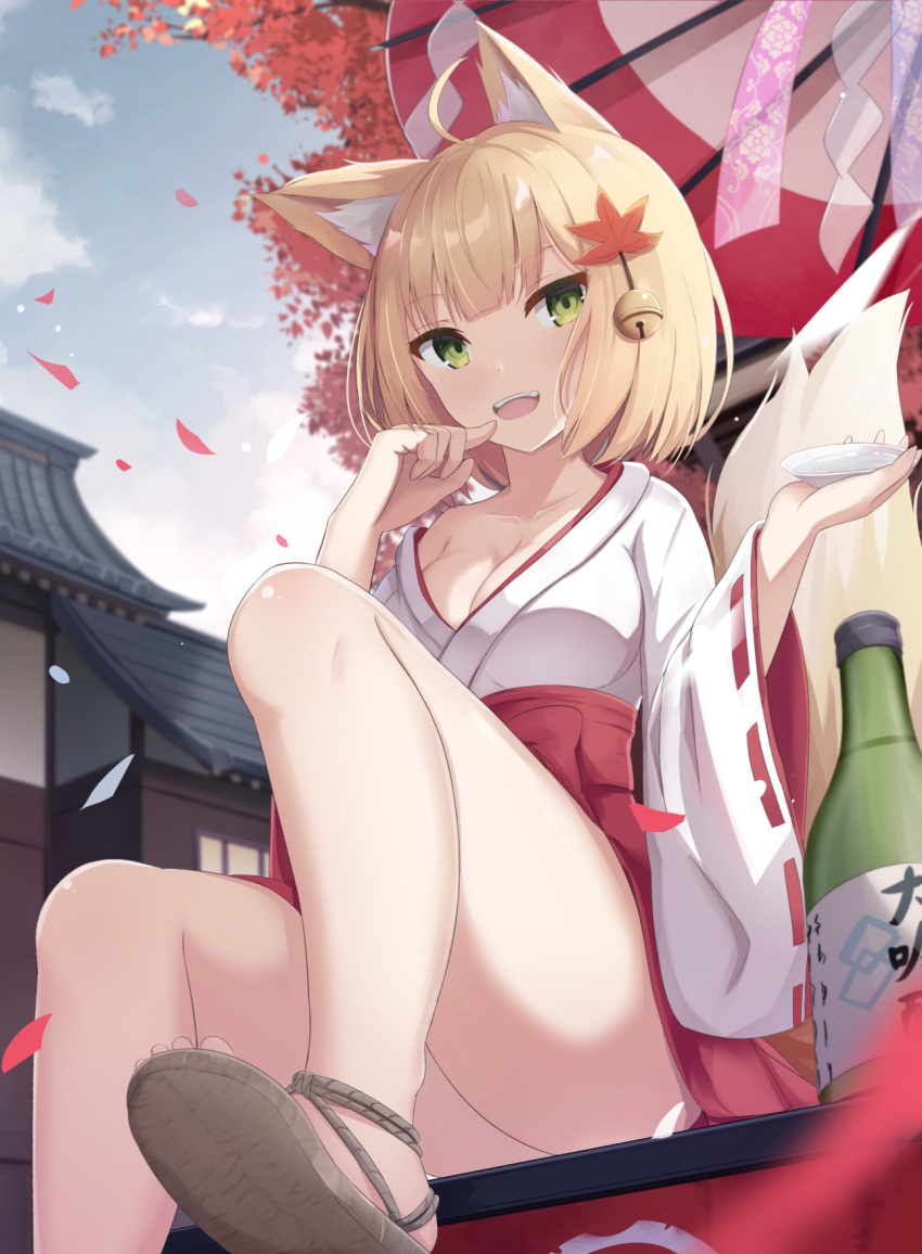 1girl animal_ears architecture autumn_leaves bangs bell blonde_hair bottle breasts cleavage cup day east_asian_architecture fox_ears fox_tail green_eyes hair_bell hair_ornament highres japanese_clothes looking_at_viewer medium_breasts miko open_mouth original sakazuki sake_bottle sandals short_hair sitting solo tail touhourh waraji