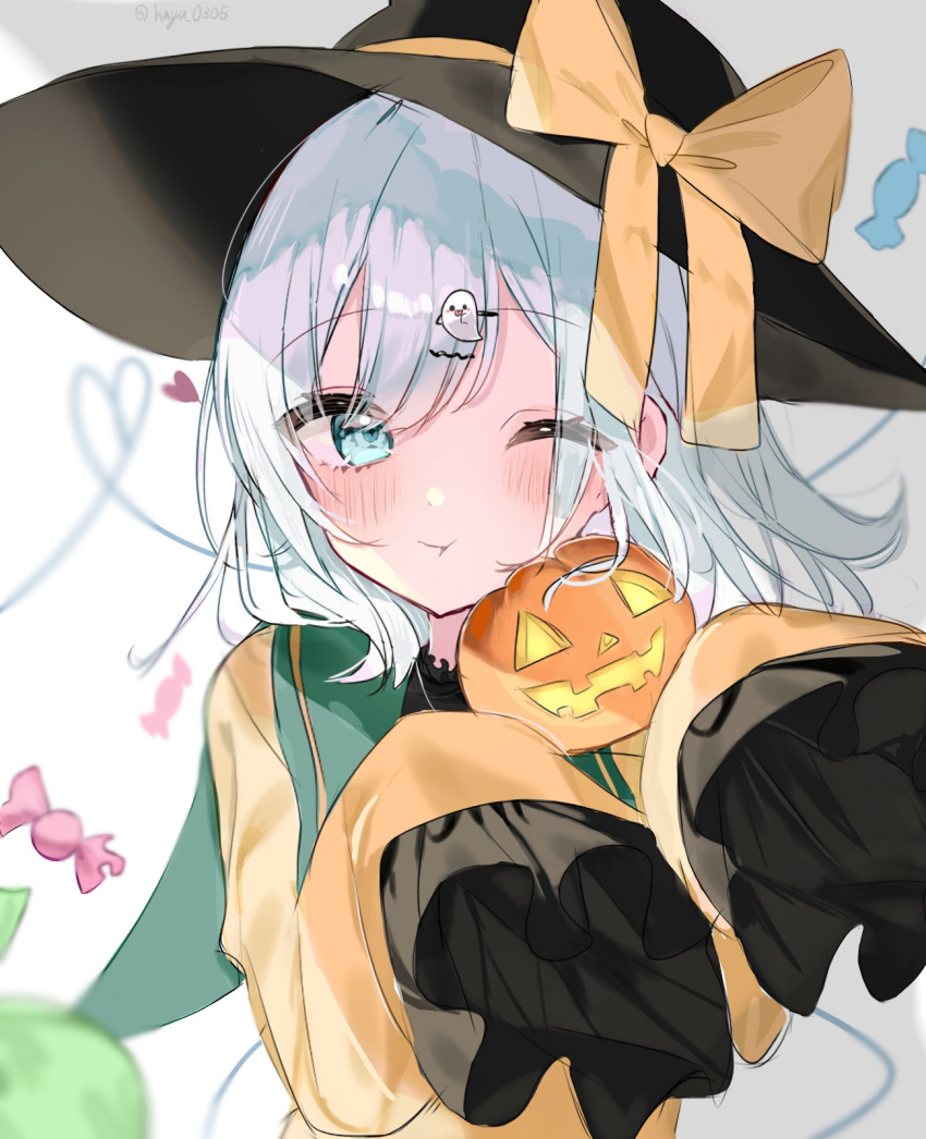1girl bangs black_headwear blurry blurry_background blush candy commentary_request eyebrows_visible_through_hair food frilled_shirt_collar frilled_sleeves frills ghost_hair_ornament green_eyes green_hair halloween hat hat_ribbon heart heart_of_string highres jack-o'-lantern komeiji_koishi one_eye_closed pout ribbon shiny shiny_hair short_hair simple_background sleeves_past_wrists solo string third_eye touhou twitter_username upper_body white_background wide_sleeves yellow_ribbon yumeno_ruruka