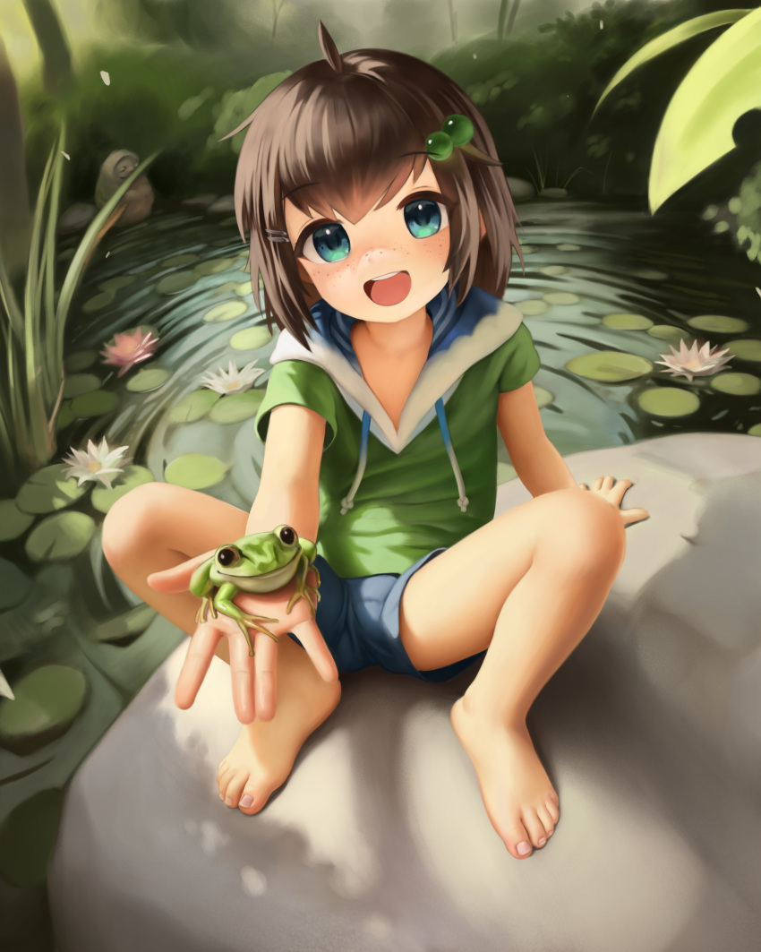 1girl :d absurdres animal_on_hand bangs bare_legs barefoot breasts child crumbles drawstring english_commentary feet freckles frog full_body green_eyes green_hoodie hair_bobbles hair_ornament highres hood hoodie lily_hopkins lily_pad looking_at_viewer medium_breasts outdoors pond rock short_sleeves shorts sitting smile solo toenails toes virtual_youtuber