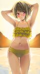  1girl :| arms_up backlighting bikini blush brown_hair closed_mouth commentary contrapposto cowboy_shot eyebrows_behind_hair frilled_bikini frills hair_flip hands_in_hair highres hinami_riku light_brown_hair looking_at_viewer love_live! love_live!_nijigasaki_high_school_idol_club multi-strapped_bikini nakasu_kasumi navel outdoors red_eyes short_hair solo standing sunset swimsuit yellow_bikini 