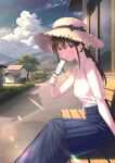  1girl :o bangs bare_shoulders bench blue_eyes blue_skirt brown_hair building cloud cloudy_sky food frilled_shirt frills hand_up hat highres holding holding_food koh_rd long_hair long_skirt looking_at_viewer mountain open_mouth original outdoors ponytail popsicle shirt sitting skirt sky sleeveless sleeveless_shirt solo straw_hat sun_hat tree white_shirt 