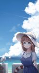  1girl arms_behind_back beach bird blue_dress blue_eyes blush boat bow breasts brown_hair chami_(pixiv15867443) closed_mouth cloud cloudy_sky commentary contrail dappled_sunlight day dress english_text fence hat hat_bow hat_ribbon highres jewelry lifebuoy looking_at_viewer medium_breasts necklace ocean original outdoors ribbon sailboat scenery seagull shirt shirt_under_dress short_sleeves sky smile solo standing sun_hat sunlight upper_body watercraft white_shirt 