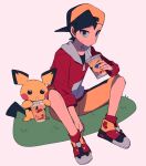  1boy backwards_hat black_hair black_shirt closed_mouth cup disposable_cup drinking_straw ethan_(pokemon) grass grey_eyes hand_up hat highres holding jacket male_focus pichu pokemon pokemon_(creature) pokemon_(game) pokemon_gsc red_jacket red_socks shirt shoes short_hair shorts sitting sleeves_rolled_up socks sweatdrop tyako_089 yellow_shorts zipper_pull_tab 
