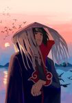  1boy abanovo akatsuki_uniform animal bird black_coat closed_mouth cloud cloud_print cloudy_sky coat fishnets flying hat headband highres male_focus mountain naruto naruto_(series) ocean open_clothes open_coat red_eyes sharingan silhouette sky solo straw_hat sun tassel uchiha_itachi water 