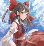  1girl absurdres ascot bangs bare_shoulders blue_sky bow brown_eyes brown_hair closed_mouth cloud cloudy_sky collared_vest commentary detached_sleeves frilled_bow frills green_ascot hair_bow hair_tubes hakurei_reimu highres kani_nyan long_hair looking_at_viewer midriff navel red_bow red_skirt red_vest sideways_glance skirt sky smile solo touhou upper_body vest white_sleeves 