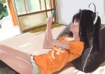  1girl ahoge black_hair cellphone clothes_writing commentary_request hands_up headgear holding holding_phone indoors lamb_(hitsujiniku) looking_away orange_shirt parted_lips phone pillow red_eyes shirt short_shorts short_sleeves shorts solo touhoku_kiritan translation_request twintails voiceroid white_shorts 