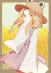  1girl bangs blonde_hair blush border brown_border brown_headwear commentary covered_mouth feet_out_of_frame hand_to_own_mouth hat highres long_hair long_sleeves moriya_suwako parted_bangs purple_skirt purple_vest sidelocks skirt solo symbol-only_commentary touhou turtleneck vest wheat_field wide_sleeves yellow_eyes yuejinlin 