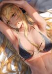  1girl :p armpits bed_sheet bikini black_bikini blonde_hair breasts collarbone commentary facial_mark fang fate/grand_order fate_(series) green_eyes long_hair looking_at_viewer lying medium_breasts mugetsu2501 navel on_back solo swimsuit tongue tongue_out upper_body vritra_(fate) vritra_(ocean_flyer)_(fate) 
