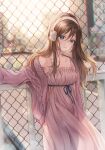  1girl bangs bare_shoulders blue_eyes blurry blurry_background blush brown_hair building cardigan chain-link_fence city closed_mouth collarbone dress expressionless fence hand_up headphones highres long_hair long_sleeves looking_at_viewer original outdoors paran pink_dress purple_cardigan sleeveless sleeveless_dress solo standing 