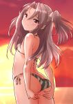  1girl alternate_costume ass bikini breasts brown_eyes cowboy_shot from_behind fuji_(pixiv24804665) gradient_sky green_bikini grey_hair hachimaki headband high_ponytail highres kantai_collection long_hair looking_at_viewer looking_back orange_sky outdoors sky small_breasts solo standing striped striped_bikini sun sunset swimsuit zuihou_(kancolle) 