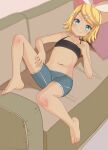  1girl aruman bangs barefoot black_tank_top blonde_hair blue_eyes blue_shorts bow brown_background collarbone commentary couch crop_top hair_bow hair_ornament hair_ribbon hairclip hand_on_own_chest hand_on_own_thigh highres kagamine_rin navel on_couch pillow ribbon short_shorts shorts solo stomach swept_bangs tank_top toes vocaloid white_ribbon 