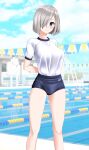  1girl absurdres alternate_costume arms_behind_back blue_buruma blue_eyes blue_sky breasts buruma cloud commentary_request day feet_out_of_frame grey_hair gym_shirt gym_uniform hair_ornament hair_over_one_eye hairclip hamakaze_(kancolle) highres kantai_collection lane_line large_breasts looking_at_viewer outdoors parted_lips pool shirt short_hair sky solo string_of_flags t-shirt takafumi white_shirt 