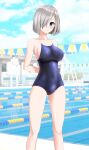  1girl absurdres alternate_costume arms_behind_back blue_eyes blue_one-piece_swimsuit blue_sky breasts cloud commentary_request competition_school_swimsuit day feet_out_of_frame grey_hair hair_ornament hair_over_one_eye hairclip hamakaze_(kancolle) highres kantai_collection lane_line large_breasts looking_at_viewer outdoors parted_lips pool school_swimsuit short_hair sky solo string_of_flags swimsuit takafumi 