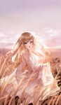  1girl :d absurdres autumn bangs blurry blurry_background blurry_foreground blush brown_hair choc clear_sky cloud commentary cowboy_shot day dress highres holding holding_clothes holding_dress leg_up light light_brown_hair long_hair long_sleeves looking_at_viewer open_mouth original pink_eyes purple_sky shiny shiny_hair sky smile solo sunset swept_bangs symbol-only_commentary walking wheat_field white_dress 
