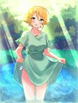  1girl akaten38 blonde_hair blush clothes_lift day dress green_dress green_eyes hair_between_eyes highres idolmaster idolmaster_cinderella_girls jewelry lifted_by_self looking_at_viewer necklace outdoors short_hair skirt skirt_lift sunlight umeki_otoha wading water 