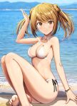  1girl barefoot beach bikini blurry blurry_background breasts commentary_request day double_bun hair_between_eyes hair_bun highres ichikawa_feesu kantai_collection light_brown_hair looking_at_viewer michishio_(kancolle) mountain outdoors sand short_twintails sitting small_breasts smile solo speech_bubble swimsuit twintails water white_bikini yellow_eyes 