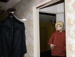  1boy 1girl black_coat black_shirt blonde_hair ceiling_fan chainsaw_man coat dark doorway facing_viewer hand_in_pocket hat highres hood hoodie hybrid katana katana_man_(chainsaw_man) looking_at_viewer military_hat red_eyes red_hoodie sawatari_akane_(chainsaw_man) shirt short_hair slit_pupils sunzo05 sword trench_coat weapon 