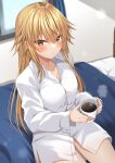  1girl ahoge blonde_hair blush breasts cup hair_between_eyes highres holding holding_cup indoors komori_kuzuyu long_hair long_sleeves looking_at_viewer medium_breasts nao_(kuzuyu) no_bra no_pants original shirt sitting solo white_shirt yellow_eyes 