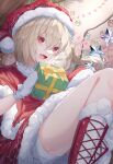  1girl :d blonde_hair blush boots bow capelet christmas_ornaments commentary crystal dress flandre_scarlet fur-trimmed_capelet fur-trimmed_dress fur-trimmed_footwear fur-trimmed_headwear fur_trim gift hair_between_eyes hat heart highres holding holding_gift looking_at_viewer lower_teeth_only open_mouth red_capelet red_dress red_eyes red_footwear red_headwear santa_hat shorts side_ponytail smile solo teeth toku_kekakewanko tongue touhou tree white_shorts wings yellow_bow 