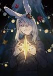  1girl animal_ears arknights bangs black_sweater christmas christmas_ornaments christmas_tree commentary english_commentary frostnova_(arknights) grey_eyes grey_hair grin hair_ornament hair_over_one_eye hairclip hands_up highres holding long_hair long_sleeves looking_at_viewer rabbit_ears resul_(scripppppp) ribbed_sweater smile solo sweater turtleneck turtleneck_sweater 