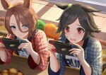  2girls animal_ears bandaid bandaid_on_face black_hair blue_eyes brown_hair clothes_writing commentary hair_between_eyes hair_ornament hairclip handheld_game_console highres holding holding_handheld_game_console horse_ears horse_girl itsuki_toiro jewel_(umamusume) kotatsu multiple_girls narita_taishin_(umamusume) nintendo_switch red_eyes shirt short_hair table umamusume winning_ticket_(umamusume) 