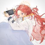  1girl bed_sheet blue_archive blue_eyes blush bow braid coat halo handheld_game_console highres hood hood_down hooded_coat long_hair long_sleeves lying messy_hair nintendo_switch nrnroooo red_hair side_braid solo under_covers upper_body very_long_hair white_bow white_coat yuzu_(blue_archive) 