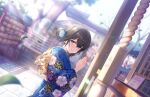  1girl black_hair blue_eyes blue_kimono blurry blurry_background blush dutch_angle falling_leaves floral_print hair_bun hatsumoude idolmaster idolmaster_cinderella_girls idolmaster_cinderella_girls_starlight_stage japanese_clothes kimono leaf lens_flare looking_at_viewer looking_to_the_side official_art outdoors palms_together rope sagisawa_fumika shimenawa shrine shrine_bell single_side_bun smile solo 