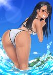  1girl ass ass_focus bikini black_eyes black_hair blue_sky brown_eyes cloud dark-skinned_female dark_skin day earclip english_commentary fang finger_to_mouth from_above highres ijiranaide_nagatoro-san looking_at_viewer looking_back nagatoro_hayase one-piece_tan outdoors rocky-ace sky solo swimsuit tan tanlines water white_bikini 